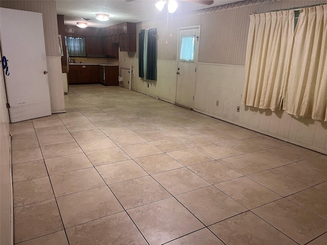 3504 Westfield Ave, Fort Worth, TX 76133 - empty room with wainscoting, light tile patterned floors, a ceiling fan, and wood walls