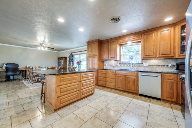 3396 County Road 302, Muenster, TX 76252 - kitchen featuring visible vents, a sink, backsplash, stainless steel dishwasher, and a kitchen island