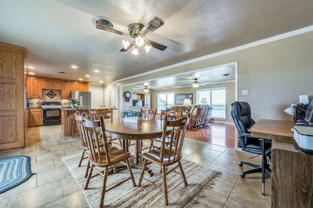 dining space featuring a textured ceiling, ceiling fan, and crown molding