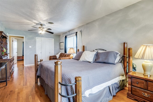 bedroom featuring a closet, light hardwood / wood-style floors, ceiling fan, and a textured ceiling