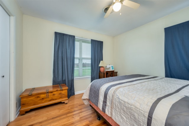 bedroom featuring light wood-type flooring, ceiling fan, and a closet