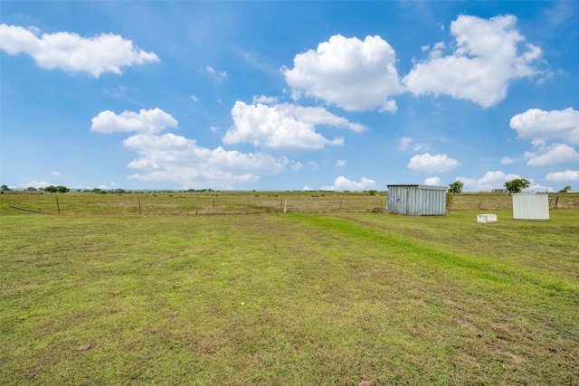 view of yard featuring a storage unit and a rural view