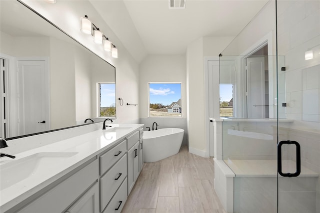 bathroom with a stall shower, visible vents, a sink, and a soaking tub