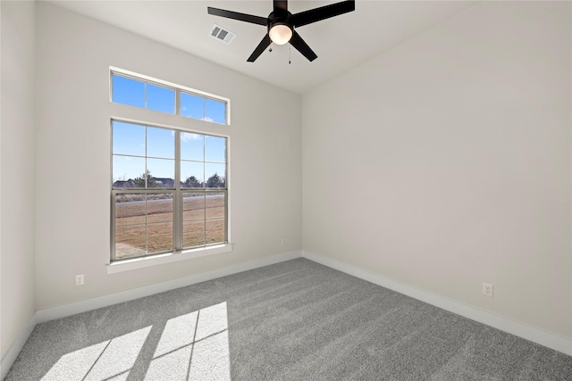 carpeted spare room featuring a ceiling fan, visible vents, and baseboards