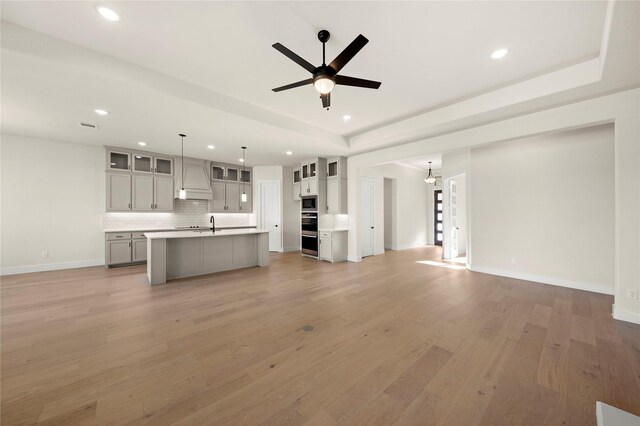 kitchen featuring pendant lighting, light stone countertops, black appliances, and sink