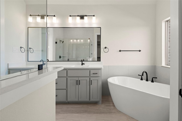 bathroom featuring vanity, shower with separate bathtub, and tile walls