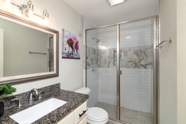 bathroom with a textured ceiling, an enclosed shower, vanity, and toilet