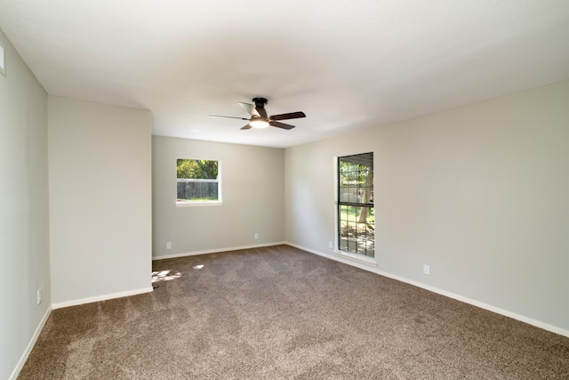 carpeted spare room featuring ceiling fan