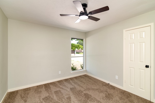 carpeted spare room featuring ceiling fan