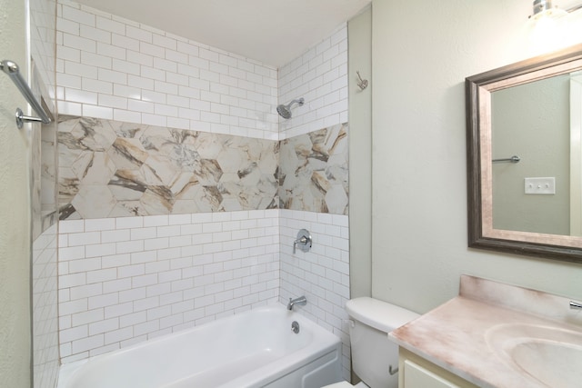 full bathroom featuring vanity, tiled shower / bath, and toilet