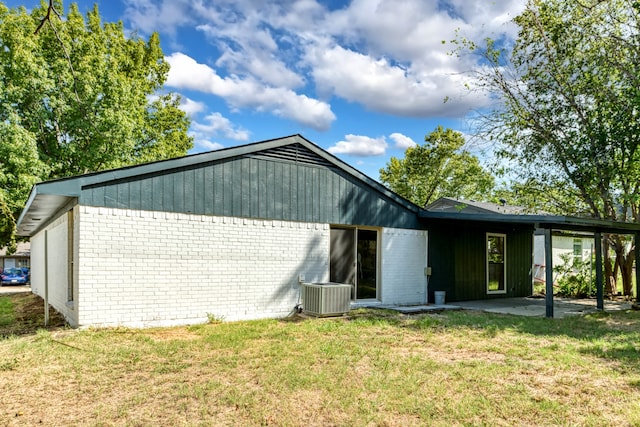 rear view of property featuring central AC unit and a yard