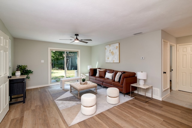 living room featuring light hardwood / wood-style flooring and ceiling fan