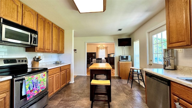 kitchen with a notable chandelier, backsplash, butcher block counters, and appliances with stainless steel finishes