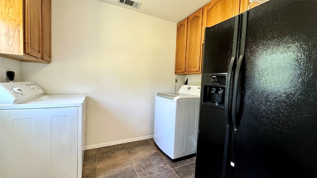 laundry area with separate washer and dryer, cabinets, and dark tile patterned flooring