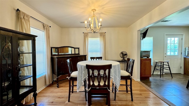 dining room featuring light hardwood / wood-style flooring and a notable chandelier