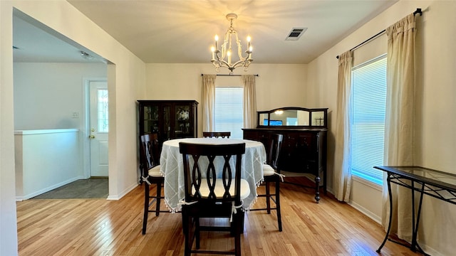 dining space with a chandelier, light hardwood / wood-style floors, and a healthy amount of sunlight