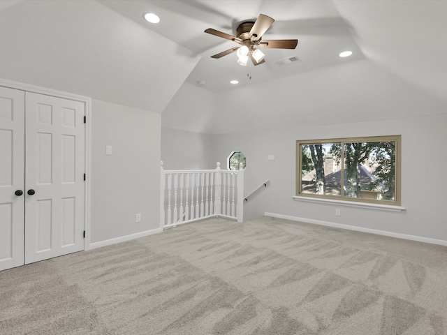 additional living space featuring ceiling fan, light colored carpet, and vaulted ceiling