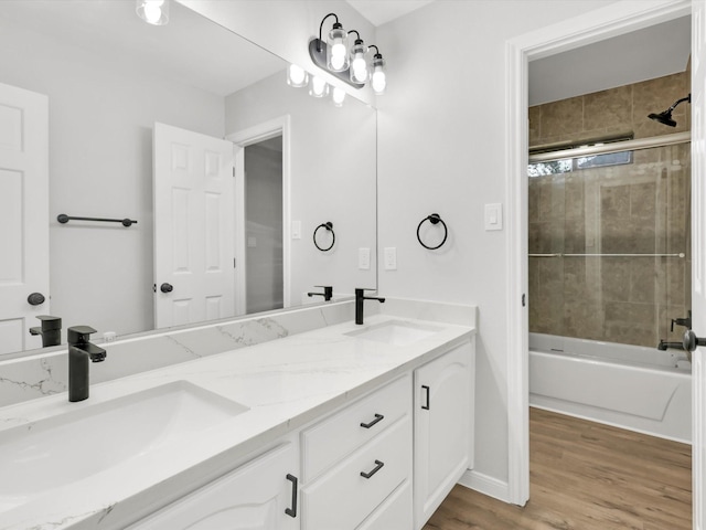 bathroom with wood-type flooring, vanity, and tiled shower / bath combo