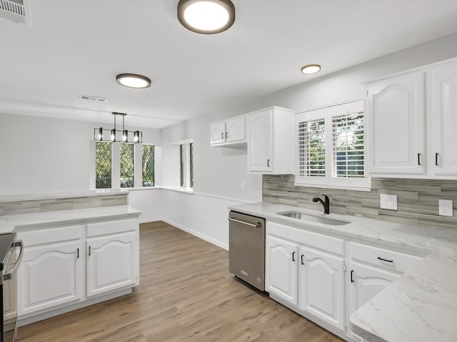 kitchen with sink, white cabinetry, hanging light fixtures, and appliances with stainless steel finishes