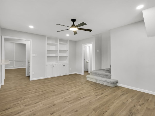 unfurnished living room with light hardwood / wood-style flooring and ceiling fan