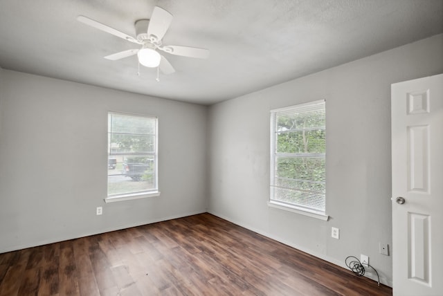 empty room with ceiling fan and dark hardwood / wood-style flooring