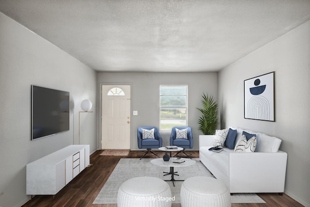 living room featuring dark wood-type flooring and a textured ceiling