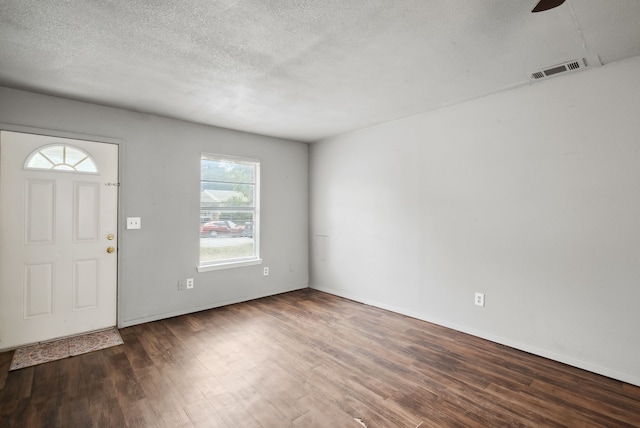 foyer entrance with dark wood-type flooring, a textured ceiling, and ceiling fan