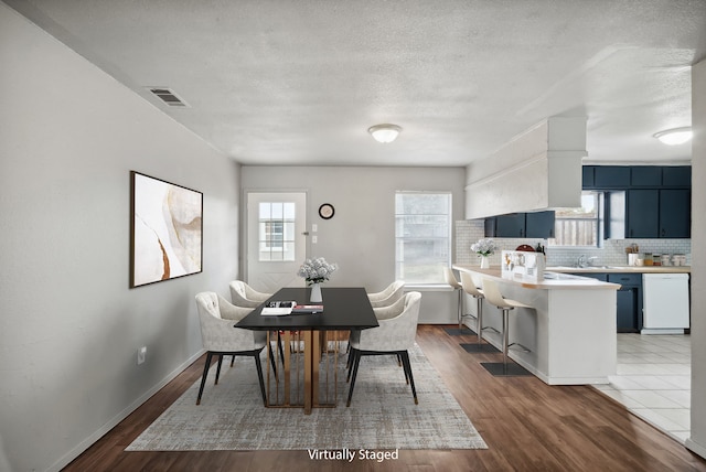 dining space featuring a textured ceiling and hardwood / wood-style flooring