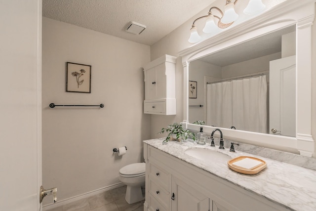 bathroom featuring vanity, tile patterned floors, toilet, and a textured ceiling