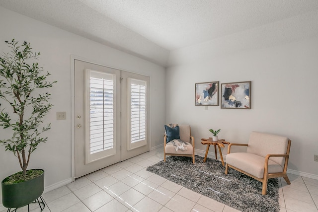 living area with a textured ceiling and light tile patterned floors