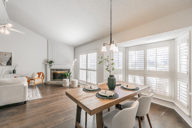 dining room featuring dark wood-type flooring, vaulted ceiling, and a textured ceiling