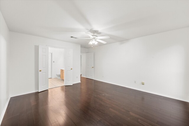 unfurnished bedroom with dark hardwood / wood-style flooring, ceiling fan, and ensuite bathroom