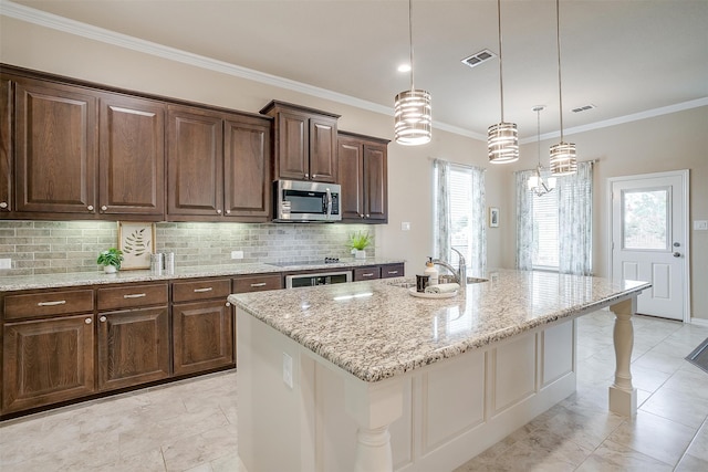 kitchen with light stone counters, a center island with sink, sink, and a kitchen breakfast bar