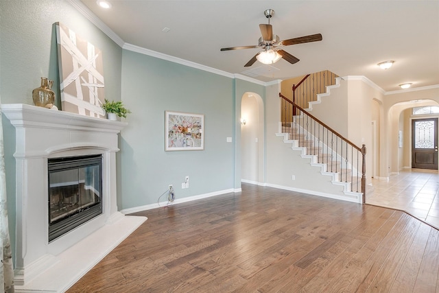 unfurnished living room featuring ceiling fan, ornamental molding, and hardwood / wood-style floors