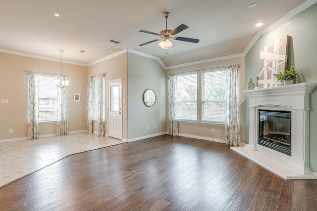 unfurnished living room with ceiling fan with notable chandelier, crown molding, and dark hardwood / wood-style flooring