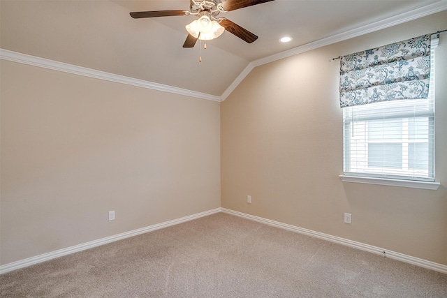 carpeted spare room with vaulted ceiling, ceiling fan, and crown molding