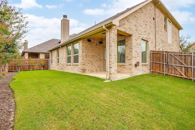 back of house with a yard and a patio