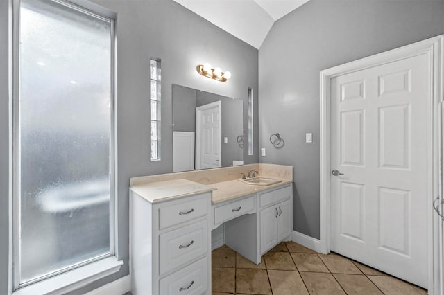 bathroom featuring vanity, vaulted ceiling, and tile patterned floors