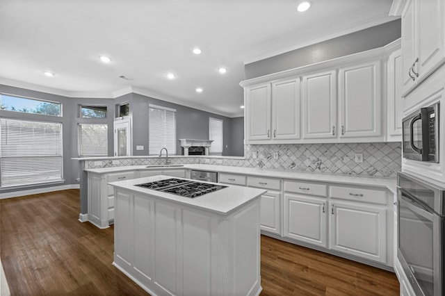 kitchen featuring kitchen peninsula, a center island, dark hardwood / wood-style flooring, and white cabinets