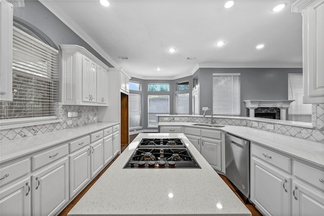 kitchen with white cabinets, ornamental molding, appliances with stainless steel finishes, and sink