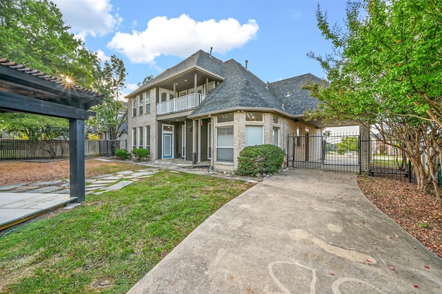 view of front of property with a balcony and a front lawn