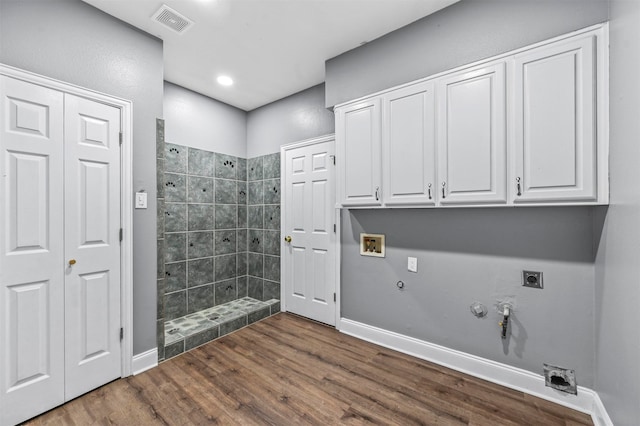 laundry room featuring washer hookup, dark hardwood / wood-style flooring, hookup for a gas dryer, electric dryer hookup, and cabinets