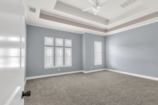 carpeted empty room featuring a tray ceiling, ceiling fan, and crown molding