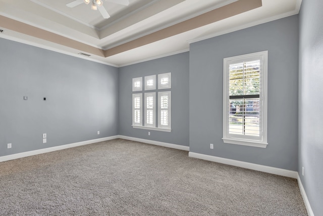 unfurnished room featuring ornamental molding, a tray ceiling, ceiling fan, and carpet floors