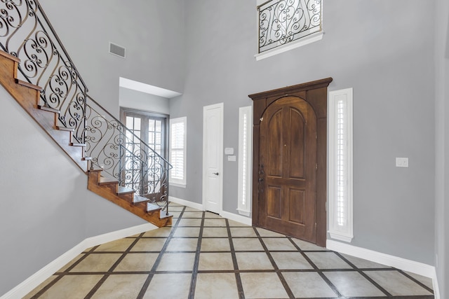 foyer featuring tile patterned flooring and a towering ceiling