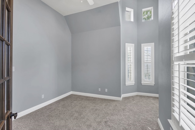 spare room with lofted ceiling, ceiling fan, and carpet floors