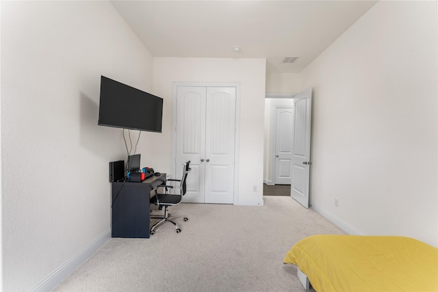 bedroom featuring light colored carpet and a closet