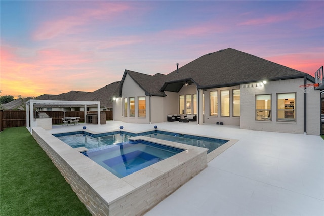 pool at dusk with an in ground hot tub, outdoor lounge area, an outdoor bar, and a patio area