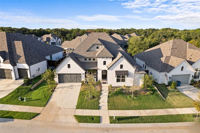 view of front of property featuring a garage, driveway, a front lawn, and roof with shingles