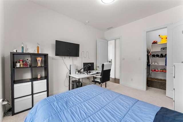 bedroom featuring light colored carpet, a spacious closet, and a closet